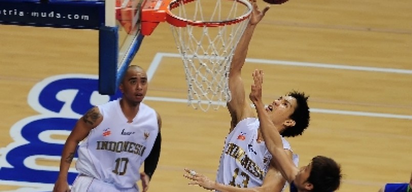 Center tim basket Indonesia, Rony Gunawan, berusaha melakukan lay up melewati hadangan pebasket Malaysia dalam laga kejuaraan South East Asia Basketball Association (SEABA) 2011, di Britama Arena Sportmall, Jakarta, Sabtu (25/6).