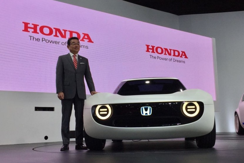 CEO Honda Motor Co Takahiro Hachigo berdiri di sebelah Honda Sport EV Concept saat diperkenalkan untuk pertama kali di ajang Tokyo Motor Show 2017 di Tokyo, Rabu (25/10).