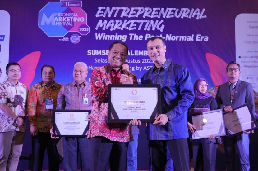 CEO MarkPlus Institute, Jacky Murssy menyerahkan Penghargaan Industry Marketing Champion 2023 kepada Direktur Utama Pusri, Tri Wahyudi Saleh.