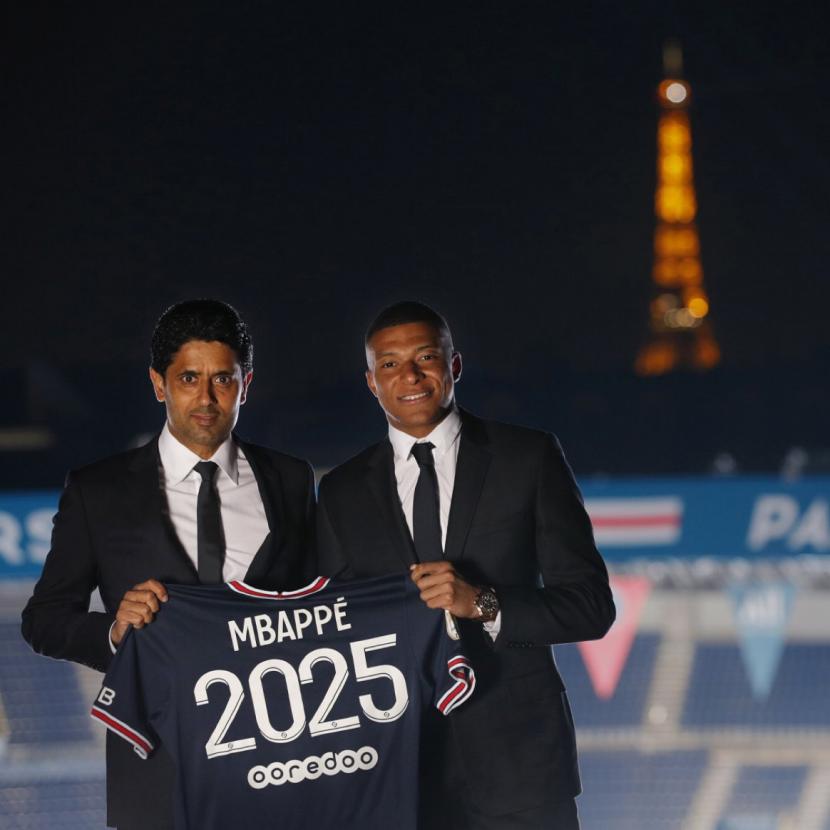 CEO PSG Nasser Al-Khelaifi berpose bersama Kylian Mbappe seusai penandatangan kontrak baru Mbappe di Paris, Prancis, Ahad (22/5/2022). Fan Real Madrid kecewa Mbappe tak jadi bergabung ke klubnya.