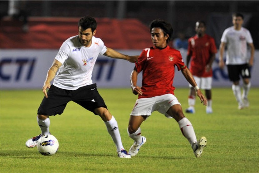 Cesc Fabregas (kiri) berebut bola dengan pesepakbola Indonesia, Taufiq, pada laga eksibisi 'Fabregas and Friends' lawan 'Tim Garuda' di Stadion Utama Gelora Bung Karno, Senayan, Jakarta, Kamis (5/7). 