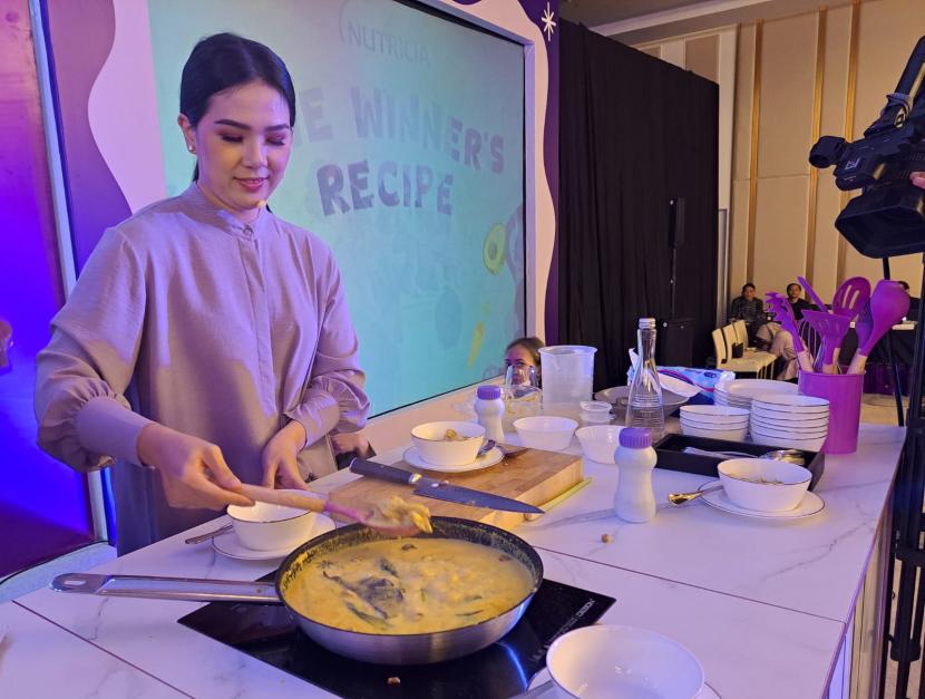 Chef Devina Hermawan mendemonstrasikan cara memasak gulai ayam di sela acara peluncuran buku The Winners Recipe besutan Nutricia. 