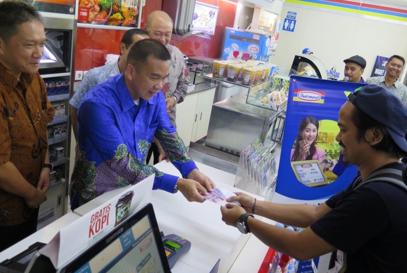 Chief Commercial Officer XL, Danny Chew Kar Wai di damping oleh Direktur Marketing PT Indomarco Pristama, Wiwiek Yusuf melayani salah satu pelanggan Indomaret yang mencoba layanan terbaru beli pulsa XL harga pas di Jakarta. Rabu (16/9)