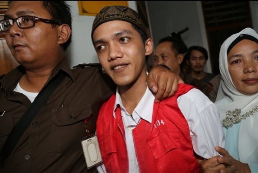 Child sexual abuse suspect Agun Iskandar, center, is escorted by security officers after his trial at South Jakarta District Court in Jakarta, Indonesia, Monday, Dec. 22, 2014. 
