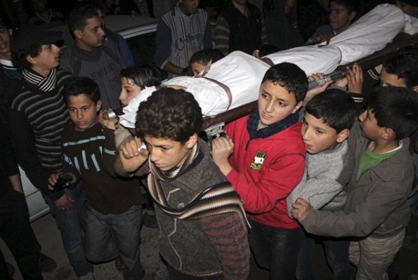Children carry the body of a friend that was killed by shelling during heavy fighting between the Free Syrian Army and the forces of Syrian President Bashar al Assad in Jobar district of Damascus January 25, 2013. 