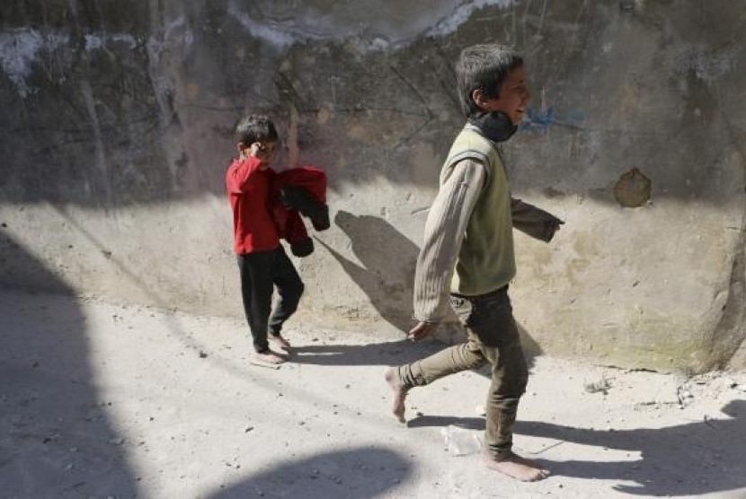 Children react after losing their mother in what activists said where explosive barrels thrown by forces loyal to Syrian President Bashar al-Assad in the Al-Andhirat neighbourhood of Aleppo February 22, 2014.