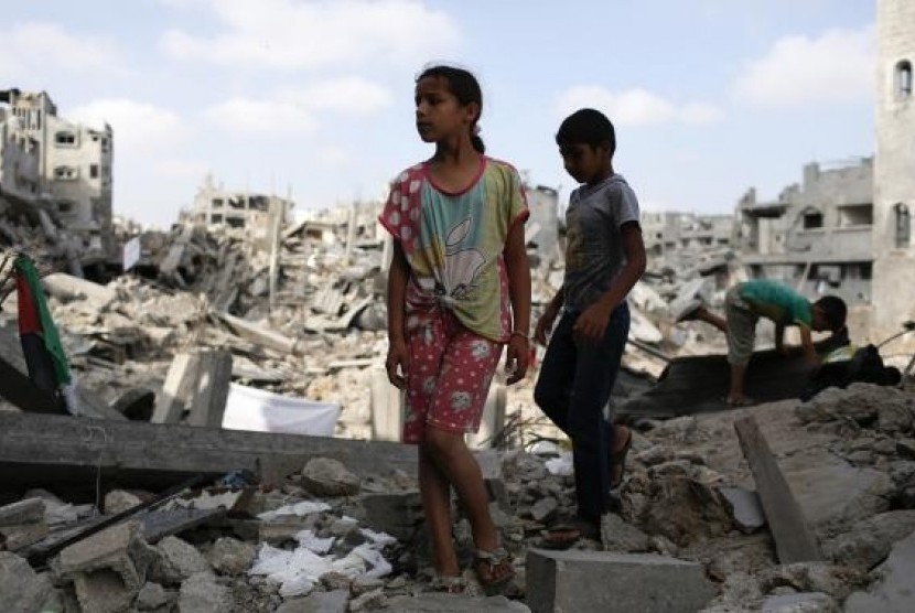 Children stand amid the ruins of their family's apartment that witnesses say was destroyed by Israeli air strikes in the Shejaia neighbourhood in Gaza City August 12, 2014.