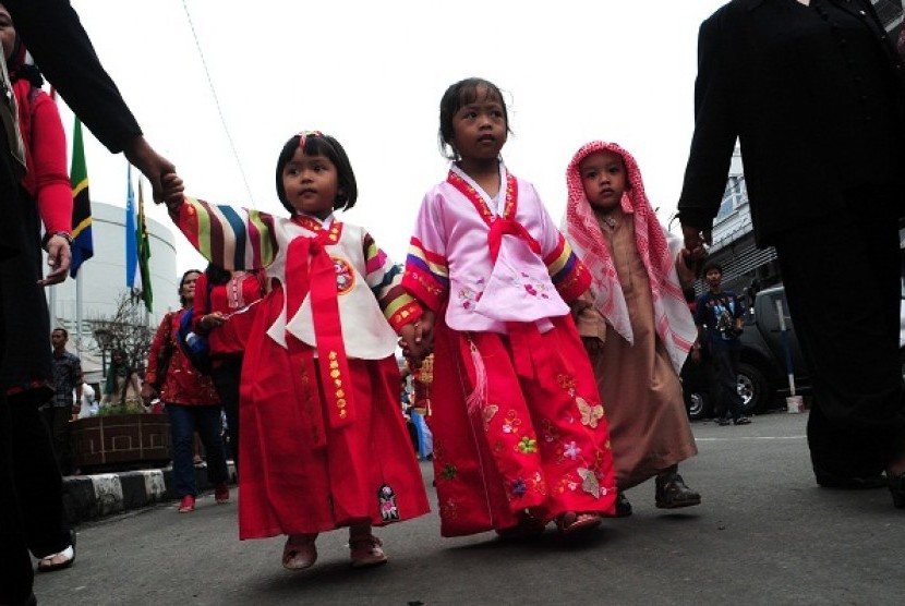 Children wears traditional dress of Korea and Saudi Arabia during a carnival in the opening of 58th Anniversary of Asian African Conference (KAA) in Bandung, West Java, on Thursday.  