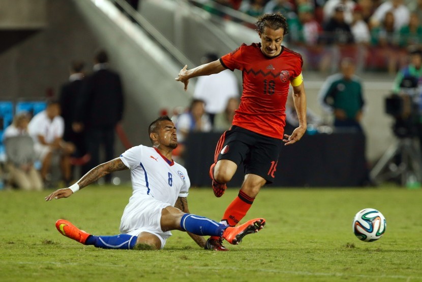 Chile midfielder Arturo Vidal (8) slide tackles Mexico midfielder Andres Guardado (18) during the first half at Levi's Stadium.