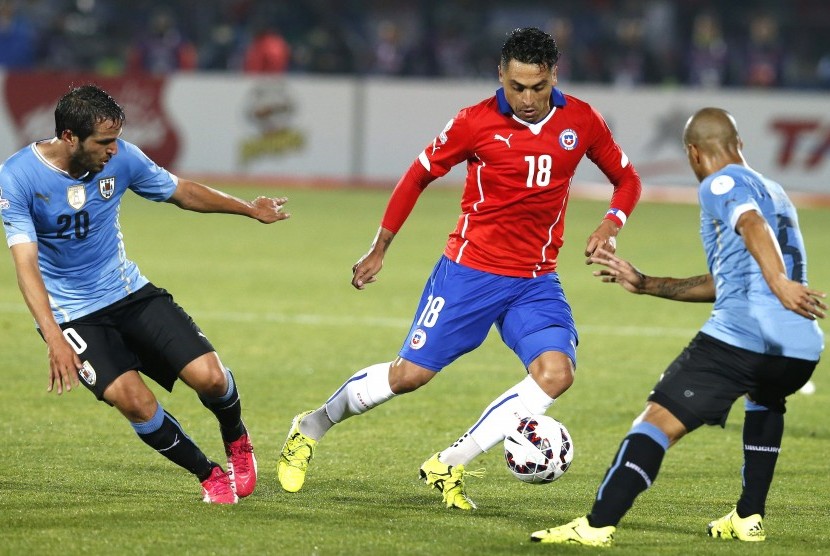 Chilean defender Gonzalo Jara (C) fights for the ball with Uruguayan midfielder Carlos Sanchez (R) and Uruguayan midfielder Alvaro Gonzalez during the Copa America 2015 quarter-finals soccer match between Chile and Uruguay, at Estadio Nacional Julio Martin