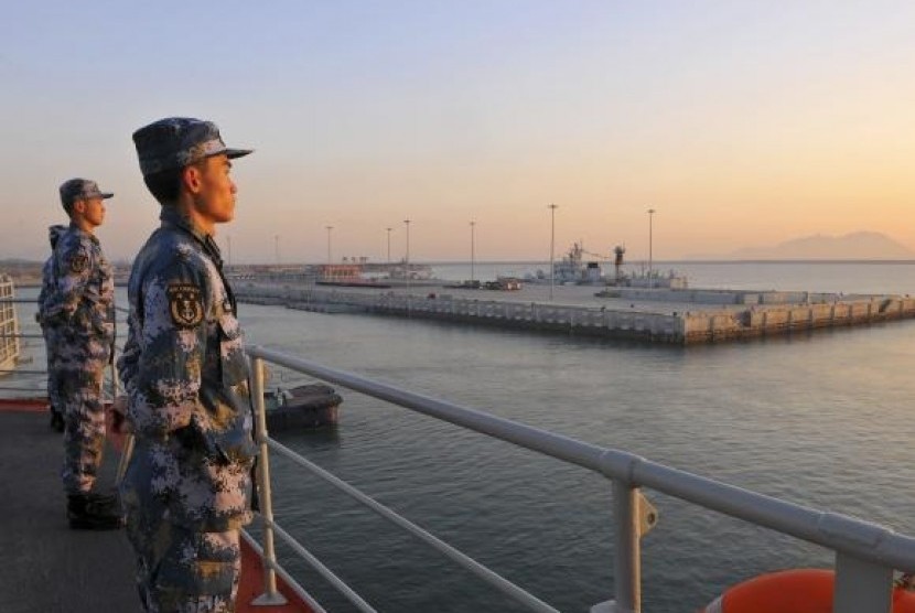 Chinese naval soldiers stand guard on China's first aircraft carrier Liaoning, as it travels towards a military base in Sanya, Hainan province, in this undated picture made available on November 30, 2013.