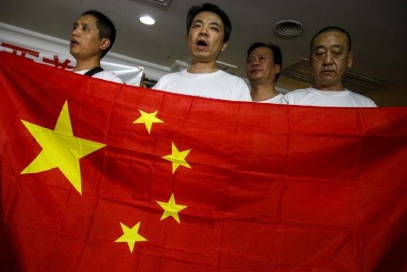 Chinese relatives of passengers onboard the missing Malaysia Airlines flight MH370 hold China's national flag during a news conference at The Holiday Villa in Subang Jaya March 30, 2014.