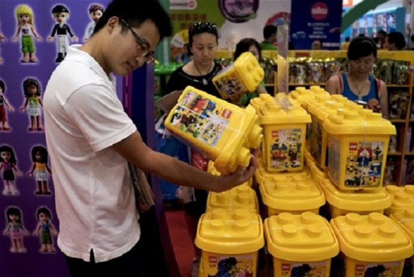 Chinese visitors look at plastic building blocks on display for sale at the Kids Fun Expo in Beijing Thursday, July 25, 2013. A deepening slowdown is challenging Chinese leaders' determination to stick with painful economic reforms they say will deliver mo