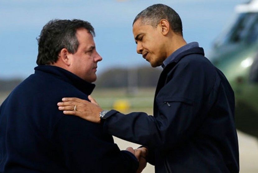 Chris Christie (kiri) menyambut kedatangan Presiden Barack Obama di New Jersey.