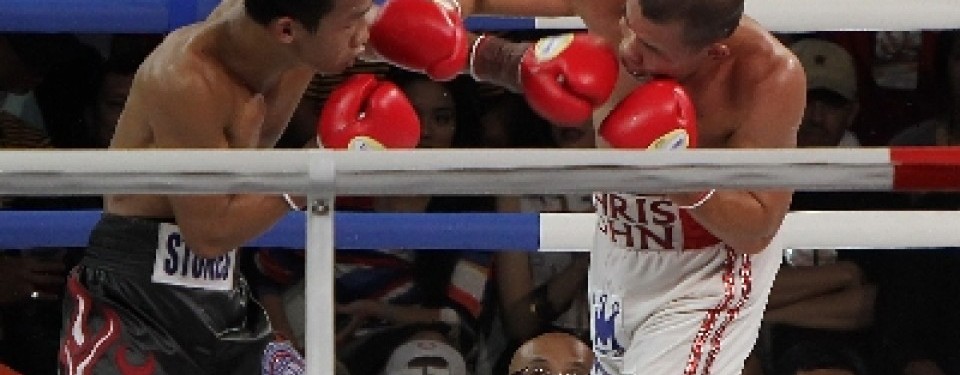 Chris John (kanan) melancarkan pukulan hook kepada Daud Yordan dalam pertandingan di PRJ Kemayoran, Jakarta, Ahad (17/4). Chris John menang angka dan mempertahankan sabuk Super Champion kelas bulu versi WBA. 