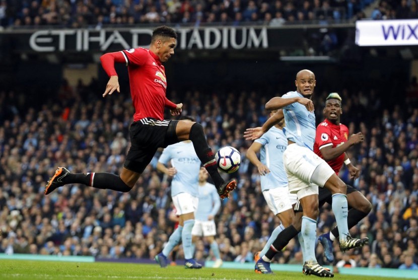 Chris Smalling (kiri) saat membobol gawang Manchester City.