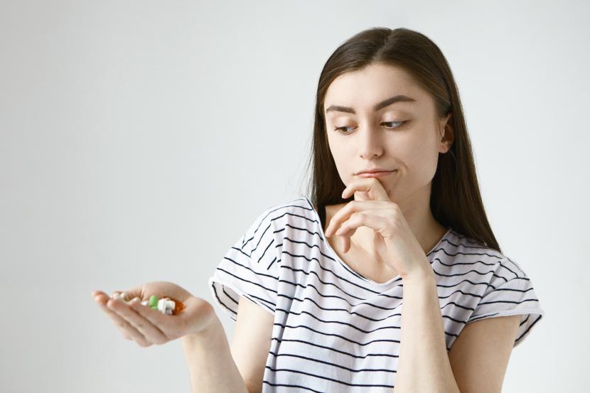 Perempuan memegang aneka suplemen (ilustrasi). Ada efek samping yang mungkin timbul, diabetesi perlu berhati-hati akan interaksi obat metformin dengan suplemen tertentu.