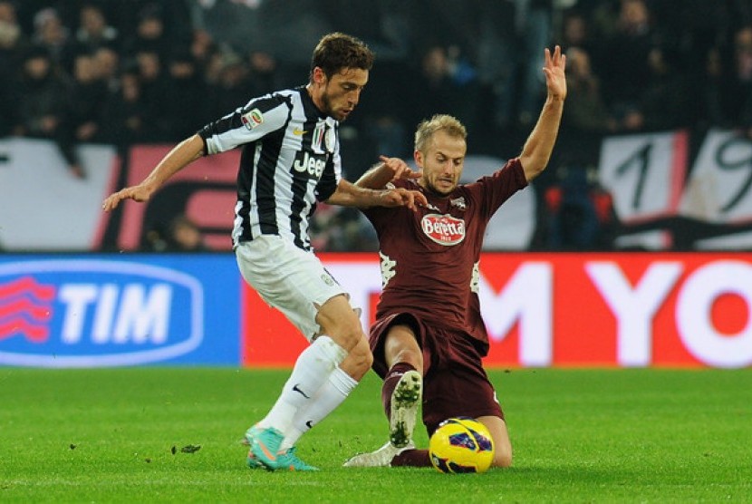 Claudio Marchisio berduel dengan Migjen Basha dalam Derby della Molle.