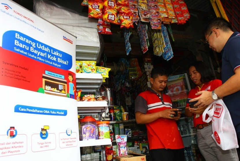 Co-Founder Tokomodal Chris Antonius (kanan) menyaksikan pedagang kelontong Outlet Binaan Alfa (OBA) melakukan pemesanan pembelian barang dagangan lewat online di Cikokol, Tangerang, Banten, Rabu (23/1/2019).