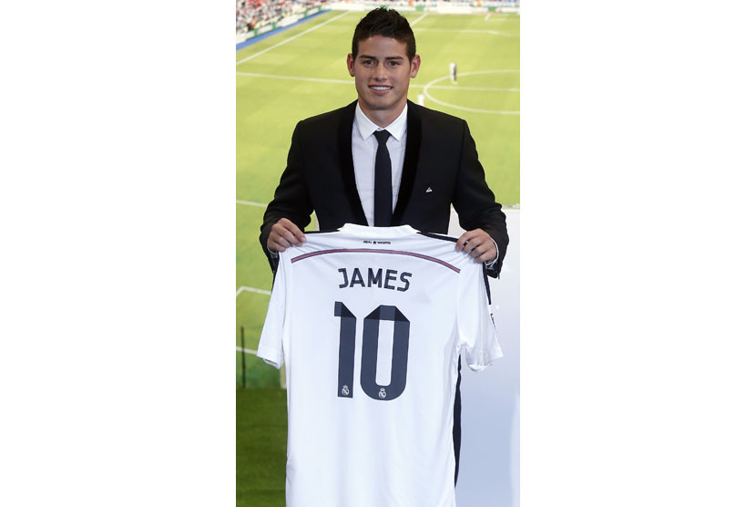 Colombia's soccer player James Rodriguez holds up his new Real Madrid jersey during a presentation at the Santiago Bernabeu stadium in Madrid, July 22, 2014. Real Madrid have signed Rodriguez from Monaco on a six-year contract, the La Liga club said on Tue