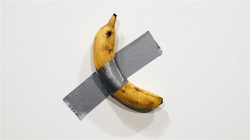 Comedian, karya seni Maurizio Cattelan, berupa pisang yang ditempel dengan lakban di dinding.