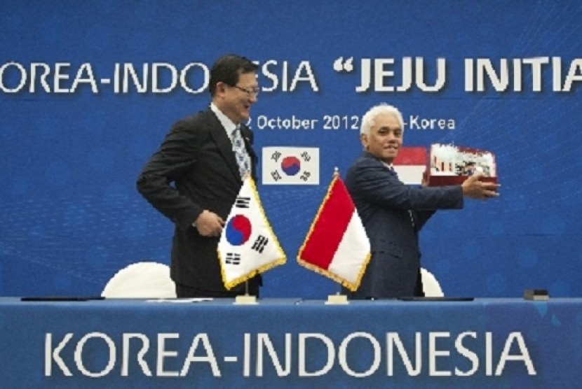 Coordinating Minister for Economic Affairs (right) shows a souvenir from South Korea`s Minister of Knowledge Economy, Sukwoo Hong, after the signing ceremony in Jeju Initiative in Jeju, South Korea, on Friday.