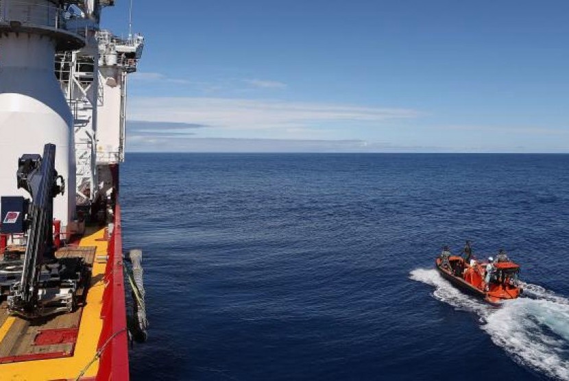Crew members are seen aboard a fast response craft (right) from the Australian Defence Vessel Ocean Shield (left) as they continue to search for debris of the missing Malaysian Airlines flight MH370 in the Southern Indian Ocean on April 8, 2014.