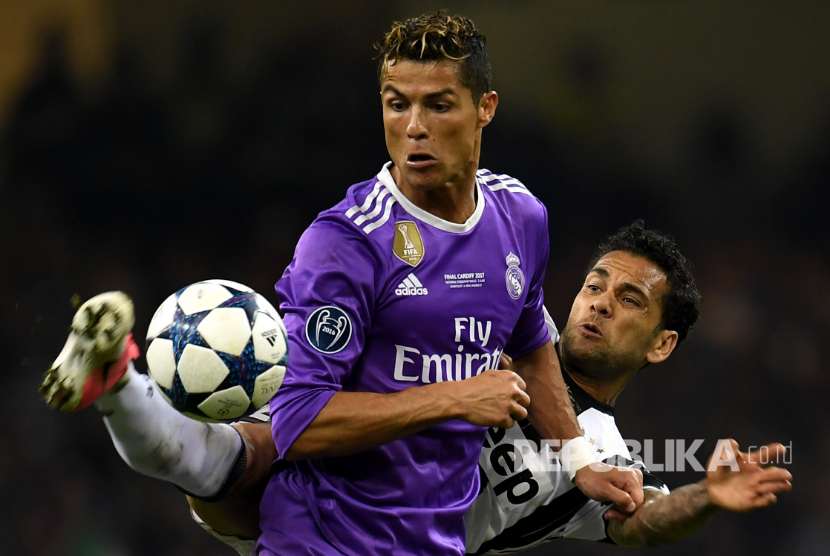 Cristiano Ronaldo (depan) dan Dani Alves berebut  bola. 