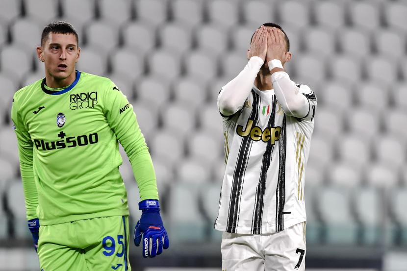 Cristiano Ronaldo dari Juventus bereaksi di samping kiper Atalanta Pierluigi Gollini setelah kehilangan peluang mencetak gol, selama pertandingan sepak bola Serie A Italia antara Juventus dan Atalanta, di Stadion Allianz di Turin, Italia, Rabu, 16 Desember 2020.