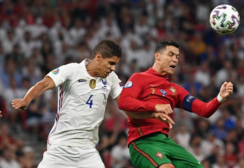 Cristiano Ronaldo dari Portugal (kanan) beraksi melawan Raphael Varane dari Prancis selama pertandingan sepak bola babak penyisihan grup F UEFA EURO 2020 antara Portugal dan Prancis di Budapest, Hongaria, 23 Juni 2021. 