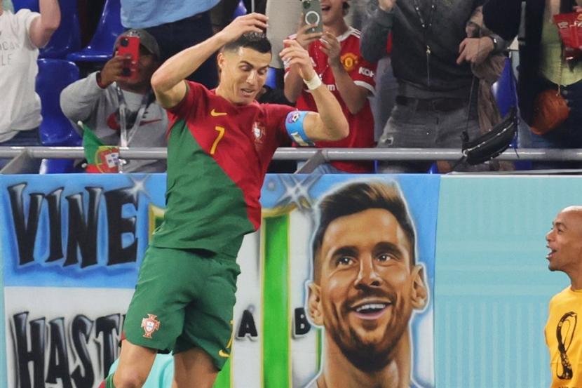 Cristiano Ronaldo dari Portugal melakukan selebrasi setelah mencetak gol 1-0 dari titik penalti di dekat poster dengan gambar Lionel Messi pada pertandingan sepak bola Grup H Piala Dunia FIFA 2022 antara Portugal dan Ghana di Stadion 947 di Doha, Qatar, Kamis, 24 November 2022. 