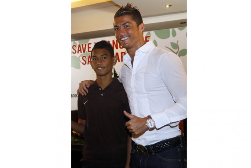  Cristiano Ronaldo (kanan) berfoto bersama anak yang selamat dari tsunami Aceh tahun 2004, Martunis (kiri) seusai memberi keterangan di Kuta, Bali, Rabu (26/6). 