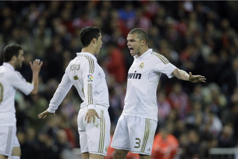 Cristiano Ronaldo (kiri), winger Real Madrid, bersama Pepe merayakan gol setelah Ronaldo menjebol jala Atletico Madrid di laga La Liga Spanyol di Stadion Vicente Calderon, Madrid, Rabu (11/4).