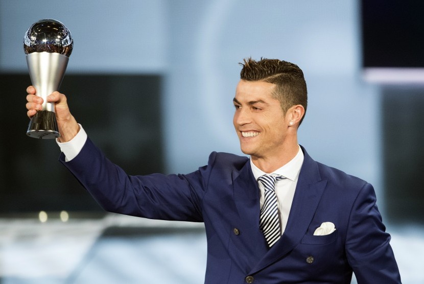 Cristiano Ronaldo mengangkat trofi pemain terbaik 2016 versi FIFA, Senin (9/1).