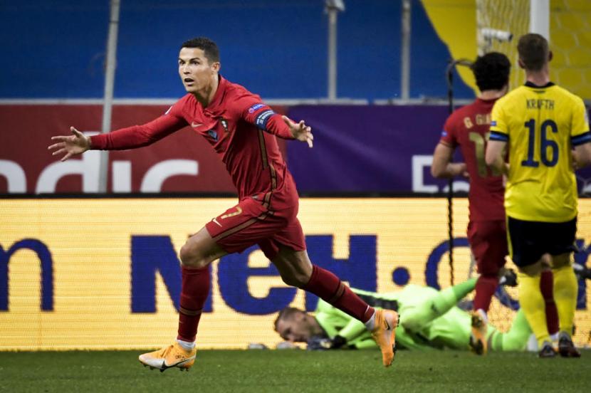 Cristiano Ronaldo merayakan golnya yang ke-100 untuk Portugal saat menjebol gawang Swedia di UEFA Nations League.