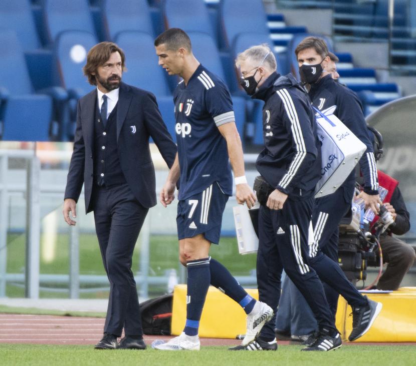 Cristiano Ronaldo (tengah), bersama pelatih Juventus Andrea Pirlo, meninggalkan lapangan karena cedera pada laga Juventus kontra Lazio di Stadion Olimpico, Roma, Italia, Ahad (8/11).