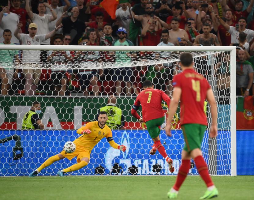 Cristiano Ronaldo (tengah) dari Portugal mencetak gol pembuka dari titik penalti pada pertandingan sepak bola babak penyisihan grup F UEFA EURO 2020 antara Portugal dan Prancis di Budapest, Hongaria, 23 Juni 2021.