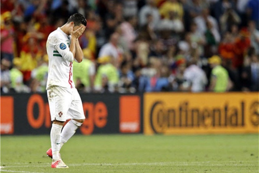 Cristiano Ronaldo, winger timnas Portugal, menutupi wajah usai kalah adu penalti dari Spanyol di semifinal Piala Eropa 2012. 