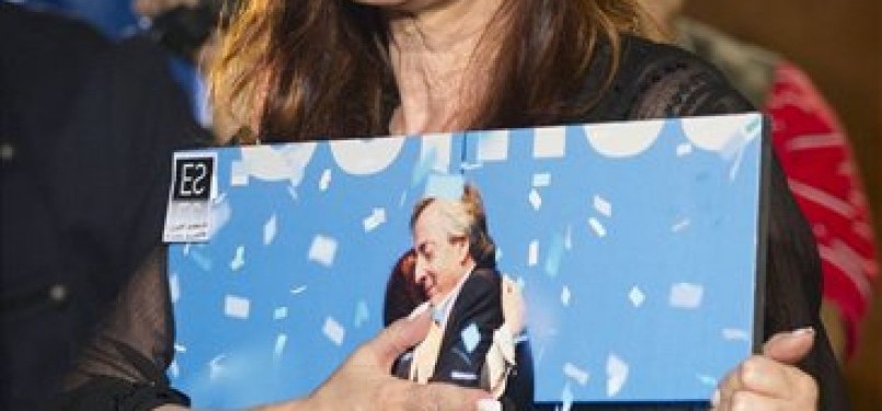 Cristina Kirchner, Presiden Argentina, memeluk foto kenangan bersama mendiang suami Nestor Kirchner.