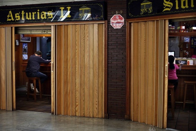 Customers sit next to empty stools at a restaurant in Torrejon de Ardoz, outside Madrid, April 16, 2013. 