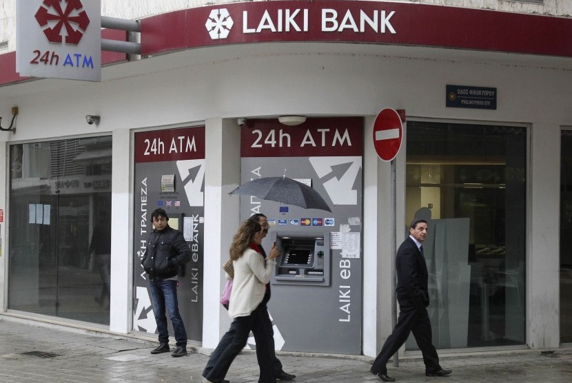 Cypriots walk pass a Cypriot bank on the island's capital Nicosia, April 18, 2013, as financial crisis shadows the future of of younger generation in Greece, Cyprus, Portugal, and Spain. (illustration)