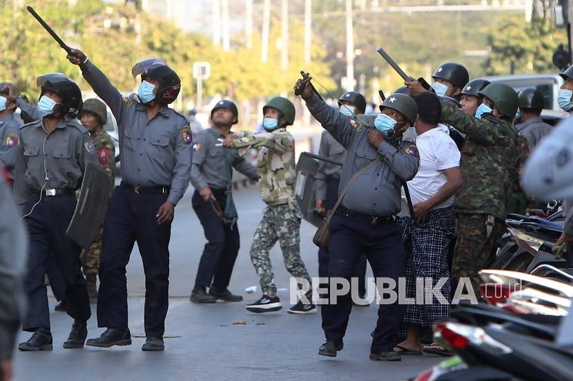 Dalam file foto 15 Februari 2021 ini, seorang polisi membidik sasaran yang tidak diketahui selama penumpasan terhadap pengunjuk rasa anti-kudeta yang mengadakan unjuk rasa di depan Bank Ekonomi Myanmar di Mandalay, Myanmar. 