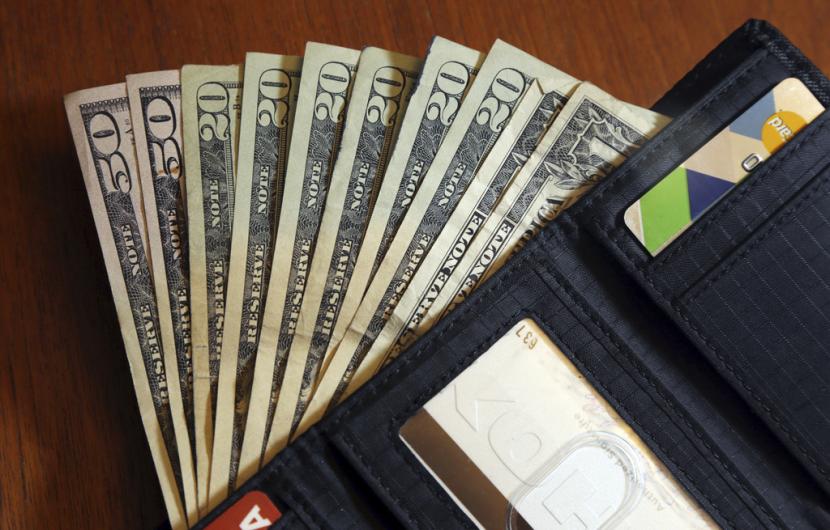 Dalam file foto 15 Juni 2018 ini, uang dolar AS disebarkan dari dompet di North Andover, Amerika Serikat. Dolar AS melemah terhadap sekeranjang mata uang utama lainnya pada akhir perdagangan Selasa.