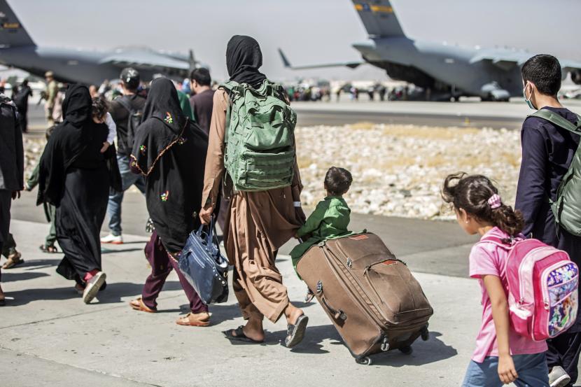 Dalam file foto 24 Agustus 2021 ini, yang disediakan oleh Korps Marinir AS, keluarga berjalan menuju penerbangan mereka selama evakuasi yang sedang berlangsung di Bandara Internasional Hamid Karzai, di Kabul, Afghanistan.