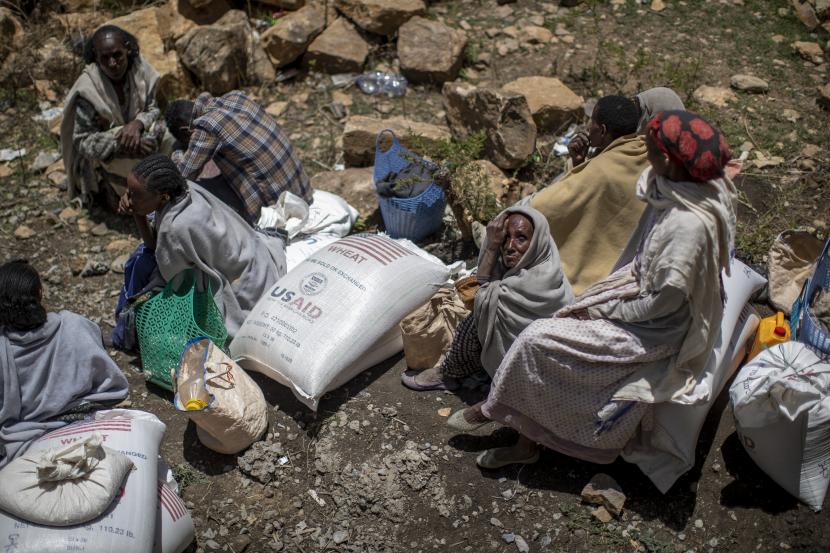 Dalam file foto Sabtu, 8 Mei 2021 ini, seorang wanita tua Ethiopia duduk di samping sekarung gandum setelah dibagikan kepadanya oleh Lembaga Pertolongan Tigray di kota Agula, di wilayah Tigray, Ethiopia utara.