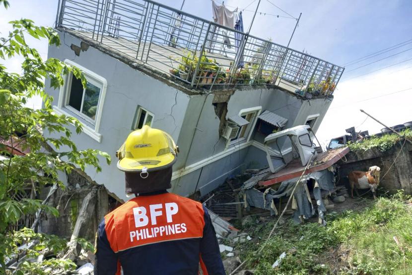Dalam foto ini disediakan oleh Biro Perlindungan Kebakaran, penyelamat memeriksa dinding rumah yang rusak setelah gempa kuat melanda Filipina. Ilustrasi.