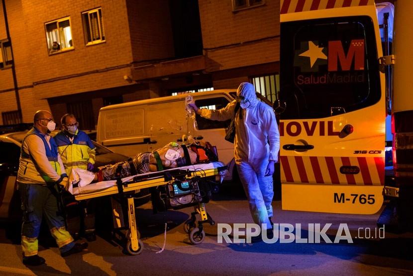Petugas ambulans dari unit Layanan Darurat Madrid (SUMMA) UVI-6 memindahkan pasien di tengah wabah koronavirus di Madrid, Spanyol. 