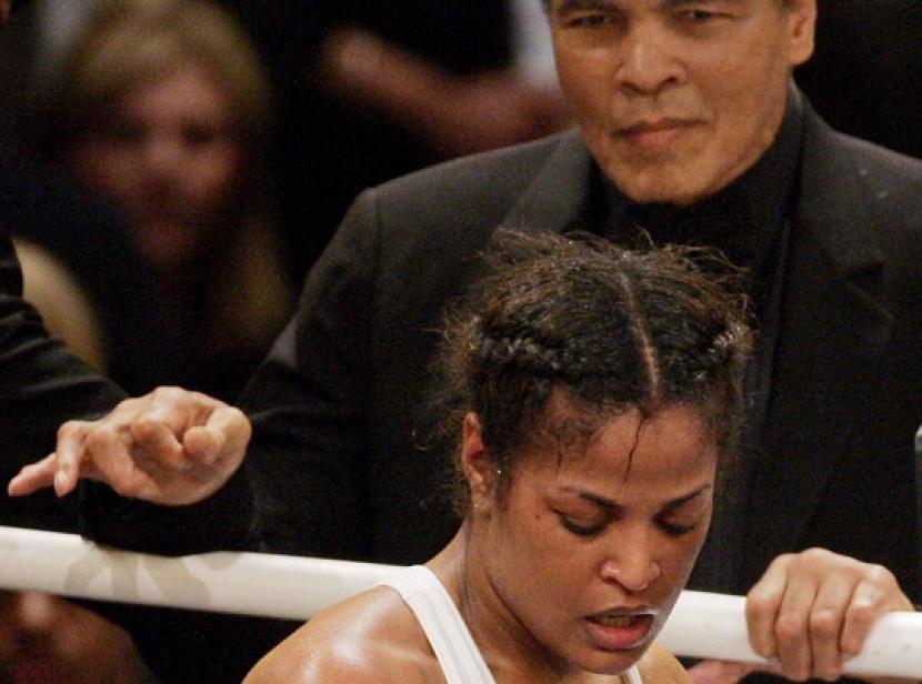 Dalam foto tahun 2005, Laila Ali tampak berlaga disaksikan ayahnya Muhammad Ali dari balik pembatas ring tinju.