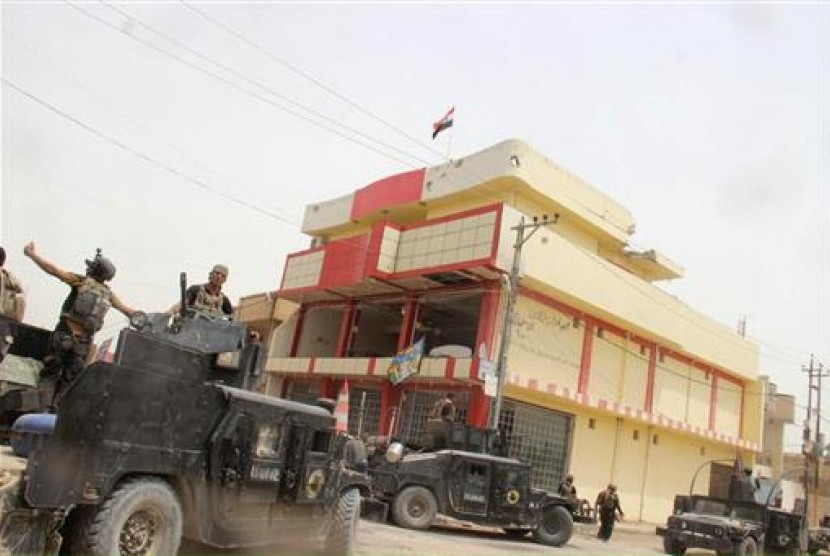 Dalam foto yang diambil fotografer dari Badan Antiterorisme Irak, Ahad, 19 Juni 2016 ini menunjukkan bendera Irak berkibar di Fallujah. Pasukan Irak merebut kota tersebut setelah dua tahun dikuasai ISIS.