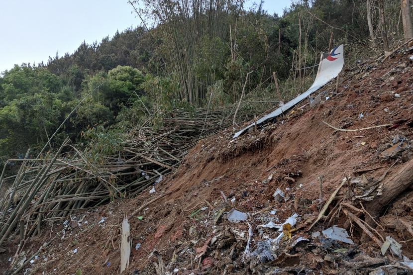 Dalam foto yang diambil oleh ponsel yang dirilis oleh Kantor Berita Xinhua, potongan puing-puing penerbangan MU5735 China Eastern terlihat setelah jatuh di gunung di Kabupaten Tengxian, Daerah Otonomi Guangxi Zhuang China selatan pada Senin, 21 Maret 2022.